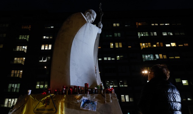 Una donna prega davanti alla statua di Giovanni Paolo II (foto Giuseppe Lami/ANSA)