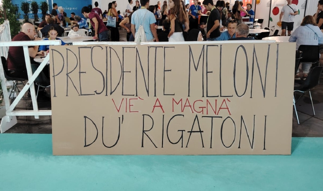 Lo striscione esposto allo stand gastronomico romano al meeting di Rimini