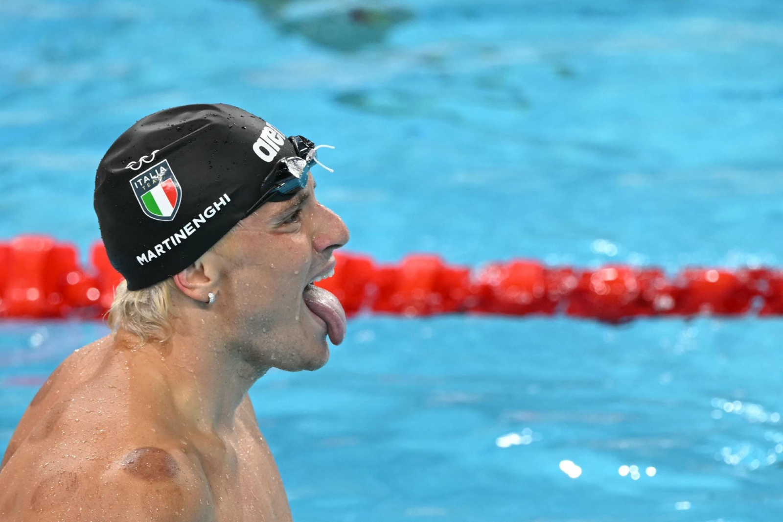 Italy's Nicolo Martinenghi celebrates after winning the final of the men's 100m breaststroke swimming event during the Paris 2024 Olympic Games at the Paris La Defense Arena in Nanterre, west of Paris, on July 28, 2024. (Photo by Jonathan NACKSTRAND / AFP