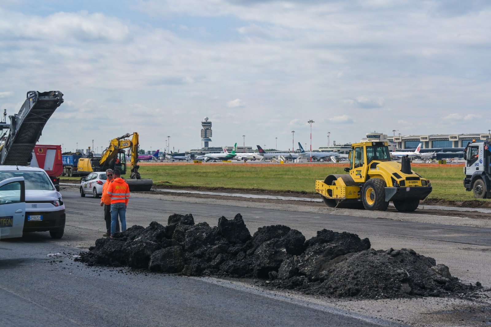 MALPENSA VISITA CANTIERE RIFACIMENTO PISTA 35L NELLA FOTO LAVORI CON SFONDO TORRE DI CONTROLLO
