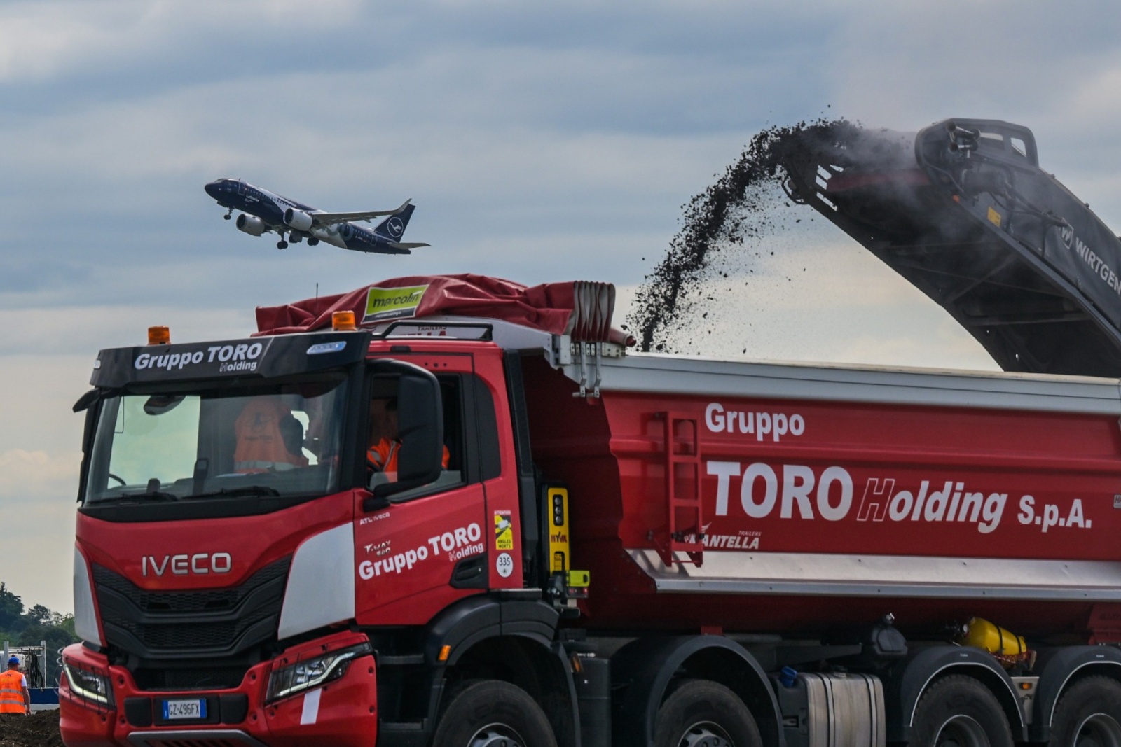 MALPENSA VISITA CANTIERE RIFACIMENTO PISTA 35L NELLA FOTO LAVORI CON SFONDO AEREO IN DECOLLO