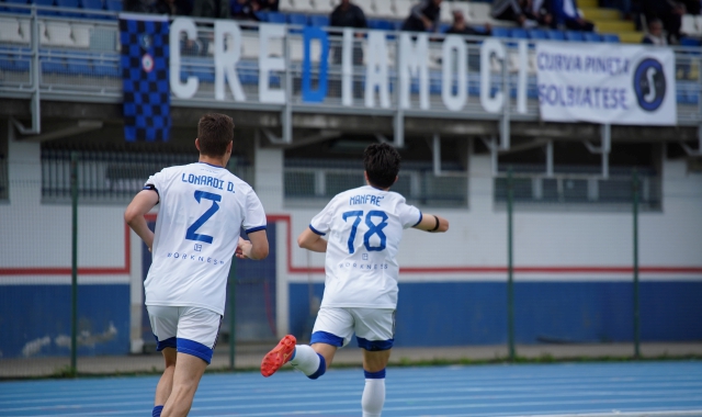 Esulta Manfrè, che ha aperto e chiuso il match contro il Mariano, sotto lo striscione che i tifosi della Solbiatese hanno esposto per caricare la squadra  (foto Samuele Lucchi)